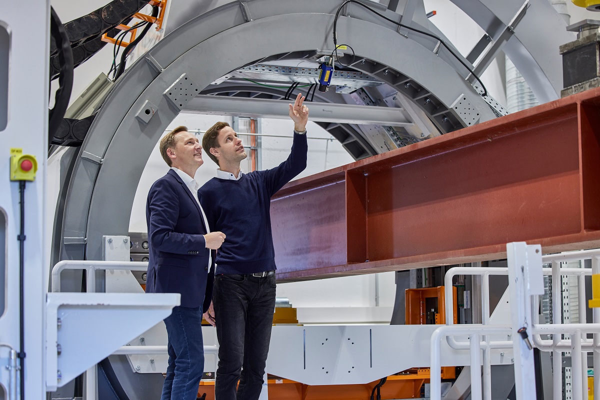 Oliver Koch vor zwei Windkraftanlagen.