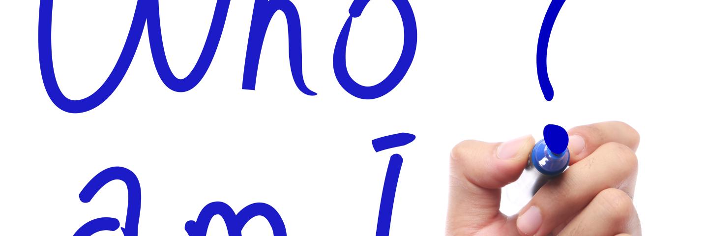 Hand mit Stift schreibt "Who am I?"